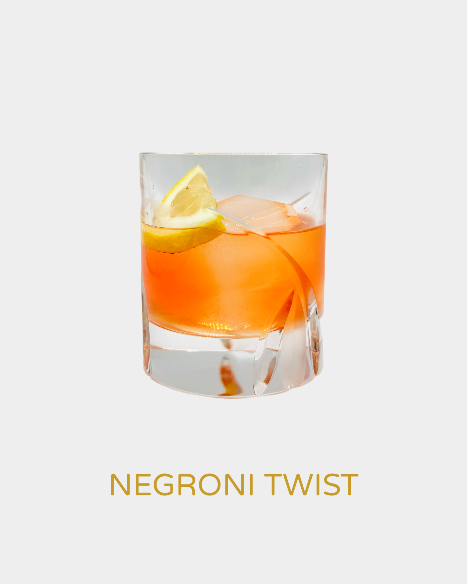 Negroni Twist cocktail in a modern crystal glass with a rich amber-orange color, garnished with a lemon slice. A bold and bittersweet variation of the classic Negroni, featuring handcrafted organic limoncello from Iannetelli Liqueurs.