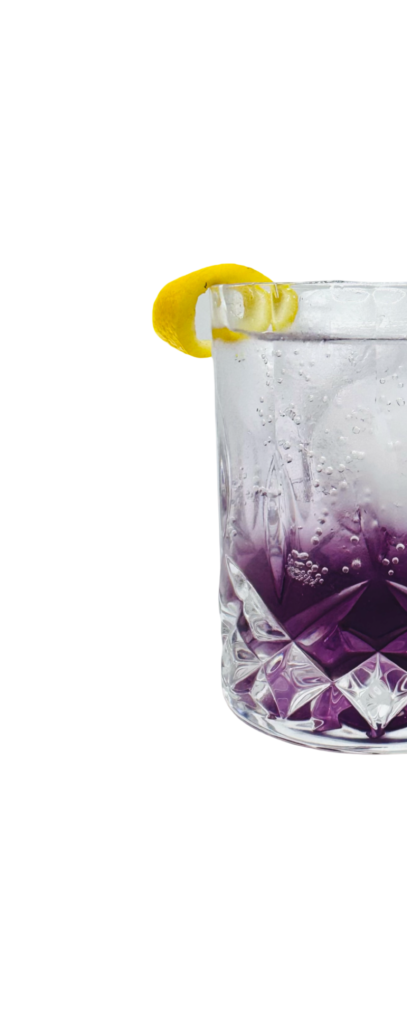 Amalfi Bloom cocktail with a lavender aroma, served over ice with a citrus garnish in a crystal glass