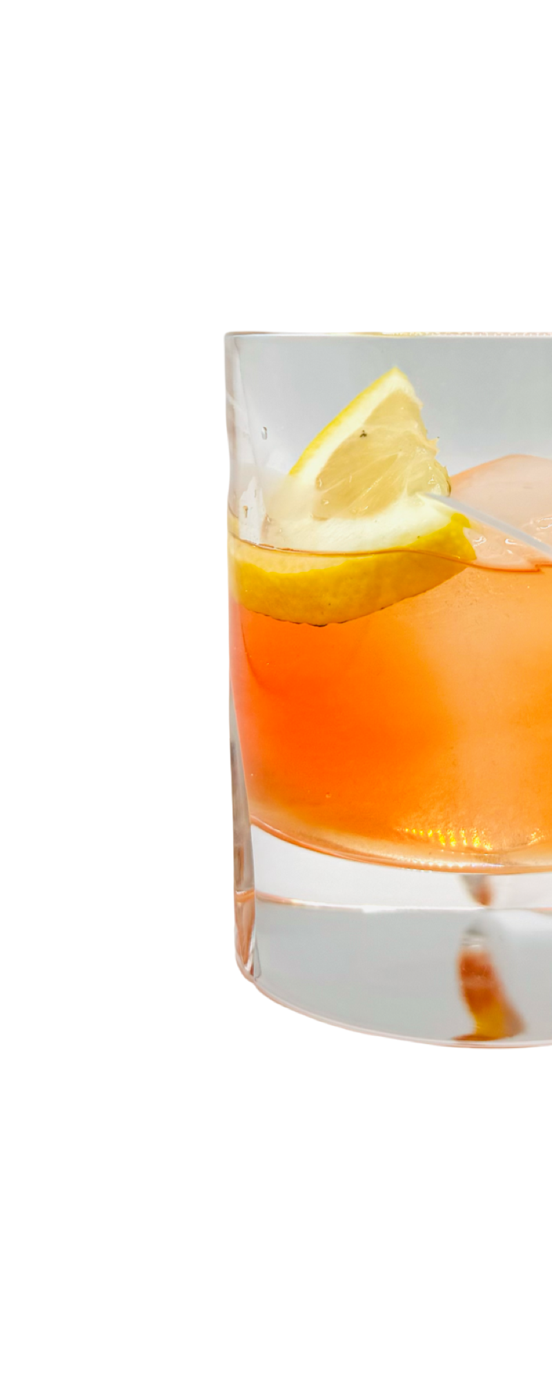 Negroni Twist cocktail with vibrant orange hues, served over ice and garnished with a lemon wedge in a short glass.